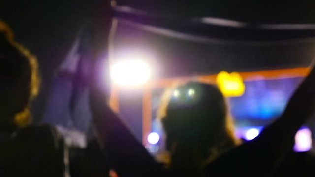 Blurred silhouettes of concert crowd in front of bright stage lights, Slow motion shot