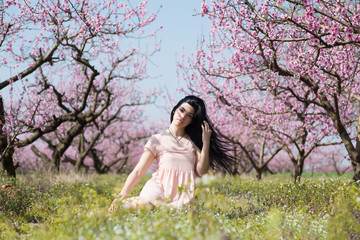 Girl in a garden of Peach's trees 