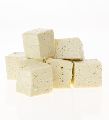 Tofu cut into cubes, isolated on white background.
