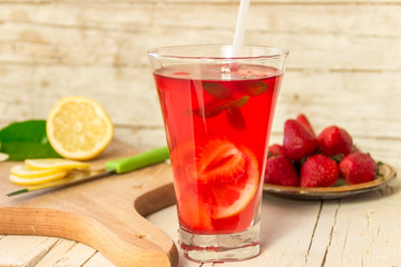Освежающий, холодный напиток с клубникой, лимоном и мятой на деревянном фоне