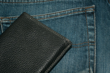 Black wallet and blue jeans back pocket.