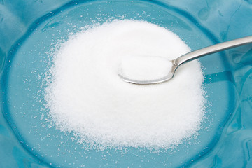 Close-up of Teal Plate and spoon with a lot of sugar