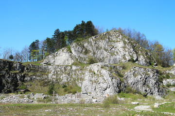 Fototapeta na wymiar rocks in former limestone quarry Kamenarka near Stramberk, Czech Republic with old stone walls under it