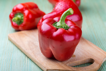Fresh organic bell peppers on a wooden board