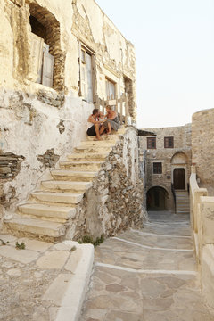Family sitting on steps of old building