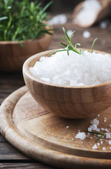 Sea salt and green rosemary in the wooden bowl