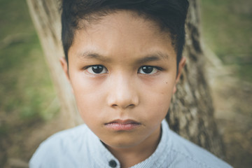 scared and alone, young  Asian child who is at high risk of being bullied, trafficked and abused, selective focus