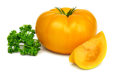 Big fresh yellow tomato and a sprig of parsley isolated on white background.