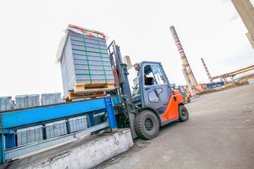 Auto loader with concrete blocks outside factory