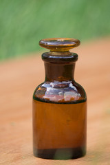 little brown bottle on booden board and grass