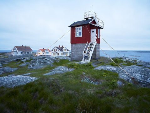 Couple sitting on steps of fishing stage at coast