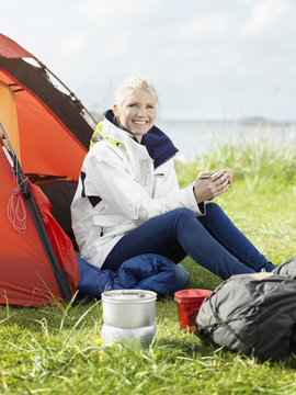 Young woman sitting in front of tent