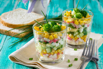 Salad with cucumber rolls in the form of roses (crab sticks, cor