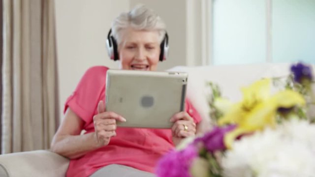 Senior woman listening music with headphone