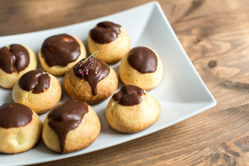 cheese profiteroles with chocolate on wooden table