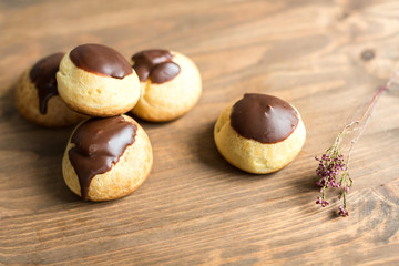 cheese profiteroles with chocolate on wooden table