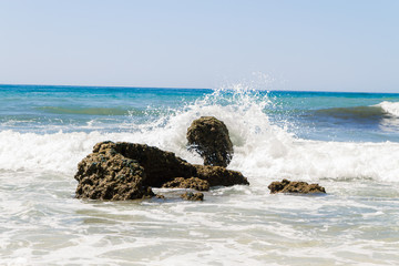 ocean waves breaking on a  stone