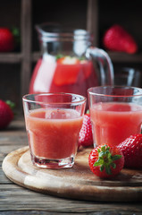 Sweet fresh strawberry juice on the wooden table