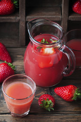 Sweet delicious strawberry juice on the wooden table