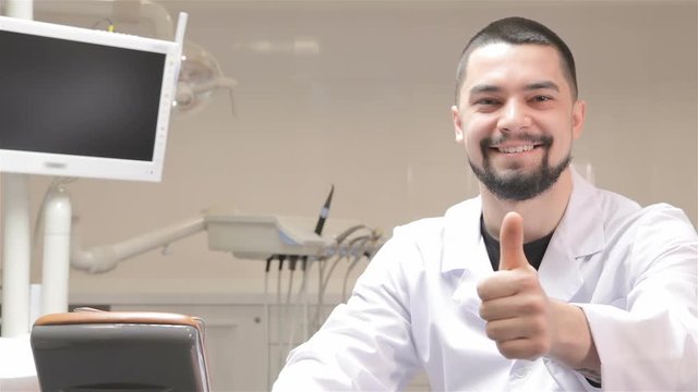 Dentist show his thumb up at the cabinet