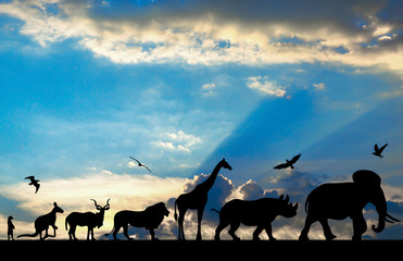 Fototapeta na wymiar Silhouettes of animals on blue cloudy sunset background