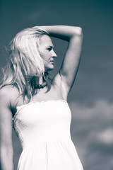 Naklejka premium Beauty blonde woman portrait on sky background.