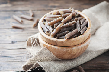 Uncooked italian buckwheat pasta on the wooden table