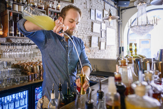 Barman preparing drink behind bar