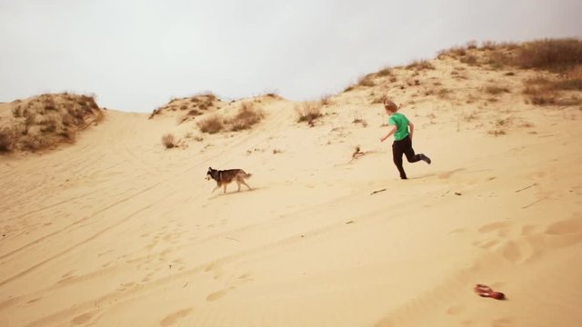 Kids playing and doing sport on sand. Slow motion