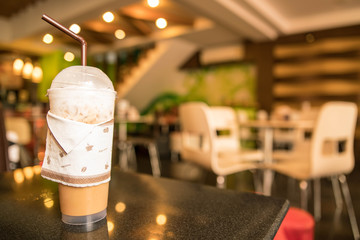 capuchino Ice coffee in plastic cup with straw on black table at cafe - copy space