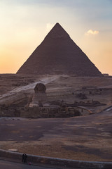 Fototapeta na wymiar The Sphinx at sunset with great pyramid of Giza in background.