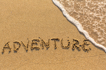 Adventure -  written on sandy beach with the soft wave.