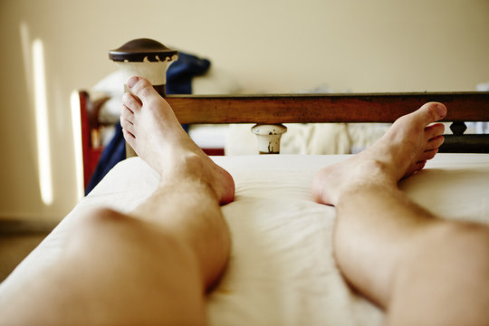Mans legs in bed