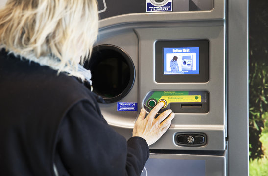 Woman using recycling bottle machine