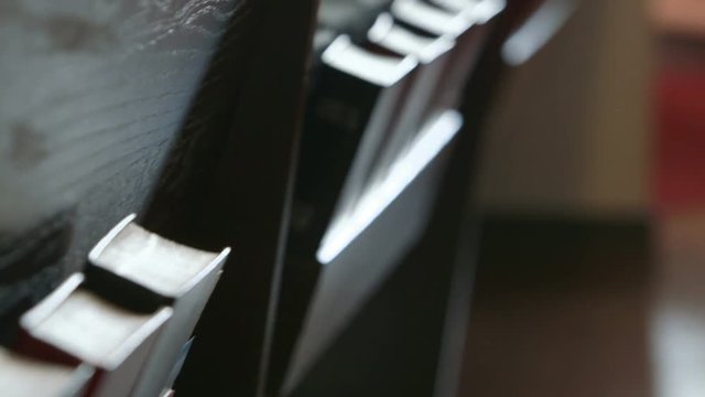 Two shots (one close-up, one medium) panning along bibles and hymnals in a church pew.
