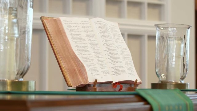 Bible and candles on altar in church