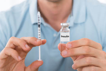 Man Holding Insulin And Syringe