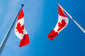 Fototapete Rund Two Canadian flags waving blue grey sky © mbruxelle