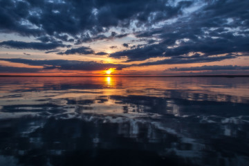 Obraz premium Storm clouds are reflected in water against a summer decline