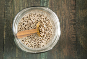 Sunflower seeds in a glass jar on wooden background