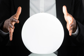 Businessperson Predicting Future With Crystal Ball - obrazy, fototapety, plakaty