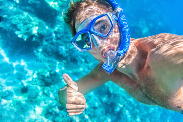 Snorkeling man underwater giving thumbs up ok signal wearing snorkel and mask having fun on beach summer holidays vacation enjoying recreational leisure time swimming in the sea. - obrazy, fototapety, plakaty