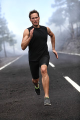 Obrazy na Plexi  Kolejny człowiek biegacz Sprint treningu na górskiej drodze. Jogging męski model fitness wypracowanie treningu do maratonu na leśnej drodze w niesamowitym krajobrazie przyrody.