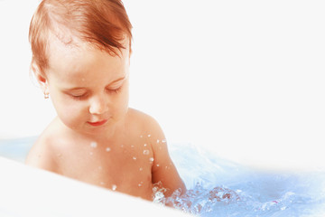 Beautiful baby girl playing with water in the bath