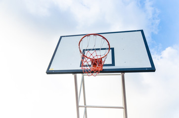 Basketball hoop on blue sky and clouds