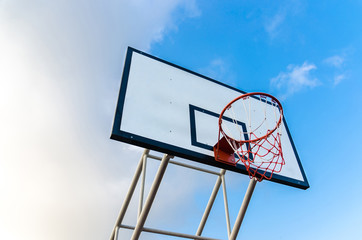 Basketball hoop on blue sky and clouds