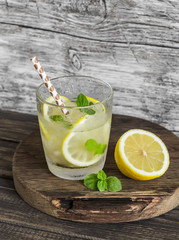 Lemon, ginger and mint lemonade on a wooden rustic board. Cold refreshing drink