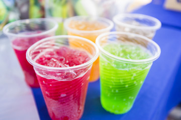 Soft drinks in plastic cups. Refreshing drink