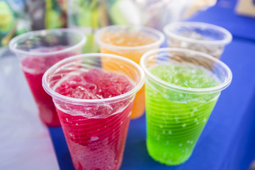 Soft drinks in plastic cups. Refreshing drink