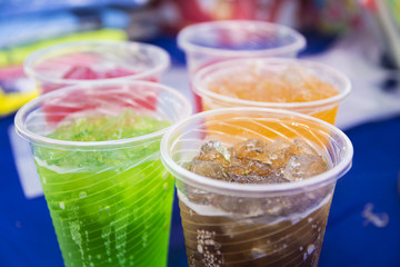 Soft drinks in plastic cups. Refreshing drink